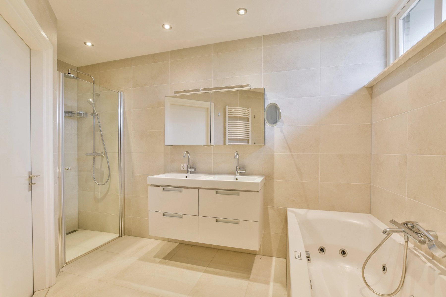 Helles fertiggestelltes Badezimmer mit Dusche, Badewanne und Doppelwaschtisch