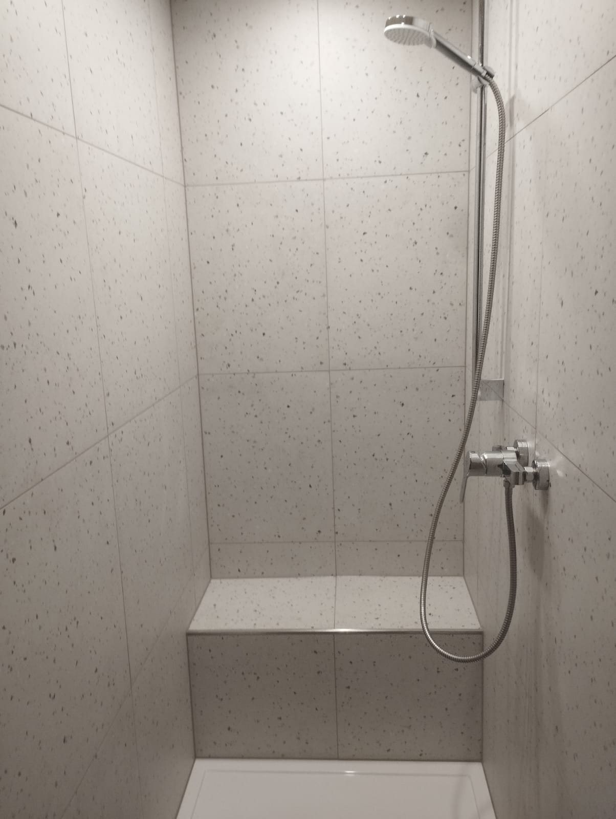 Eigene Referenz von Badmacher24: fertiggestellte Dusche mit gefliester Sitzbank und Armatur